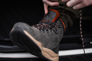 Man tying up his hiking boots tight for blister prevention.