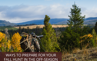 A man with a backpack and antlers on his back looking into a telescope into a forest during his fall hunt.