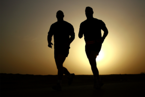 Silhouette of two men running to get prepared for hunting at high altitudes.