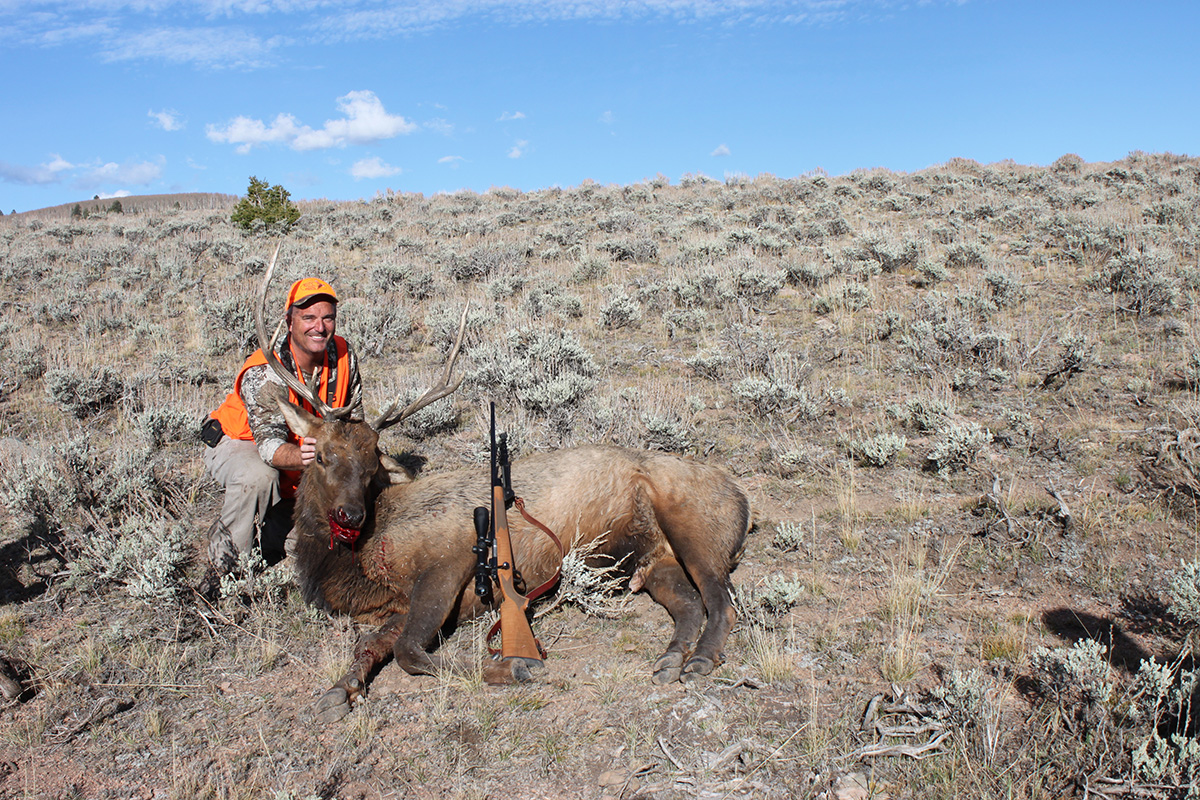 Hunter sitting next to elk