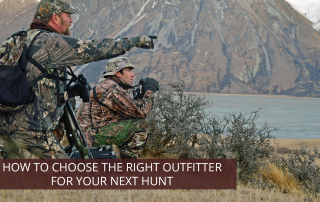An outfitter pointing out an elk to a hunter.
